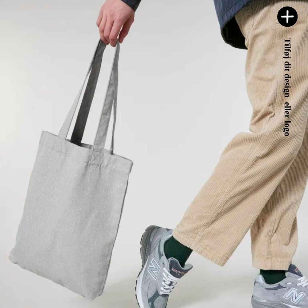 En person bærer en grå mulepose. Tilføj dit design eller logo.