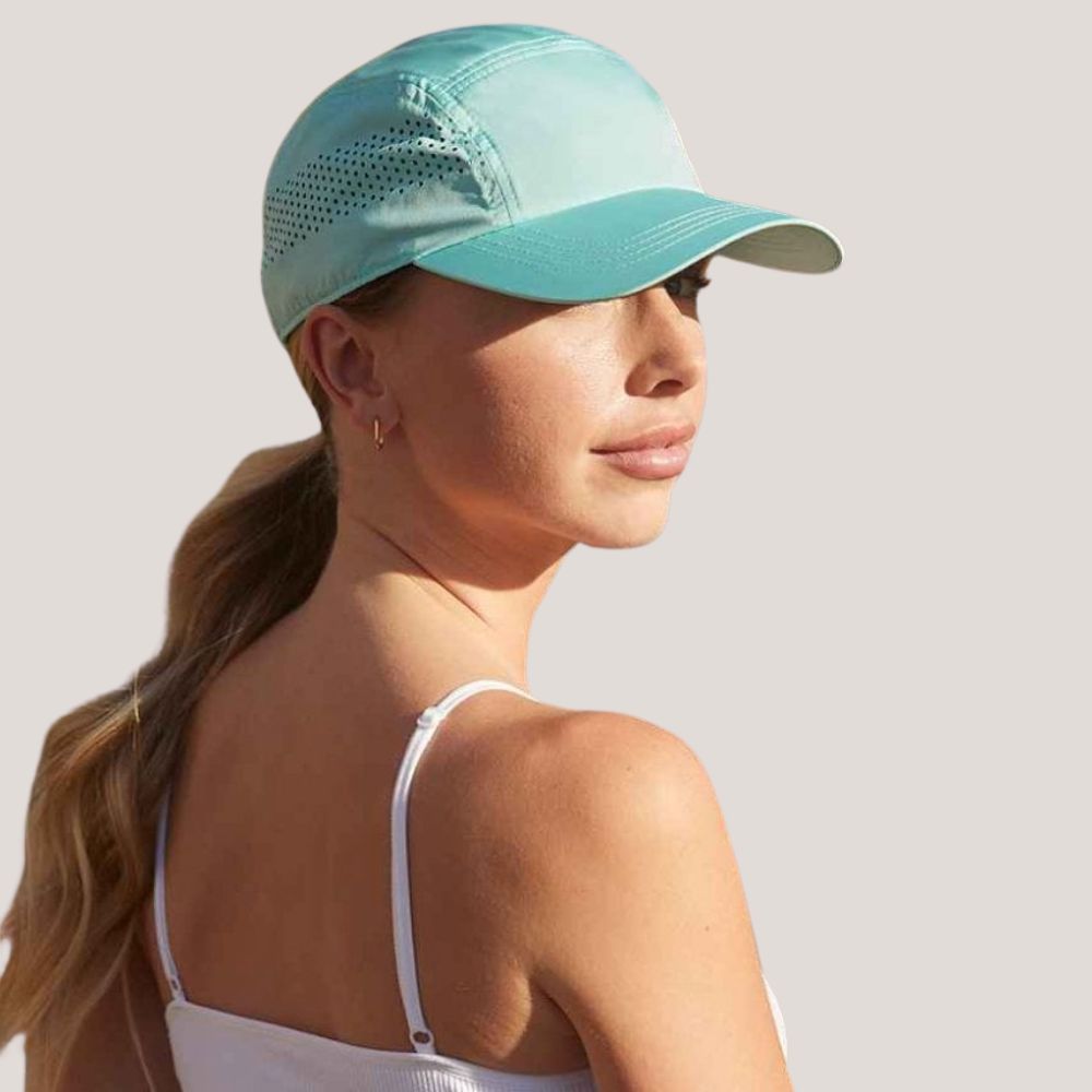 En person iført en lyseblå kasket. Tilføj dit design eller logo.